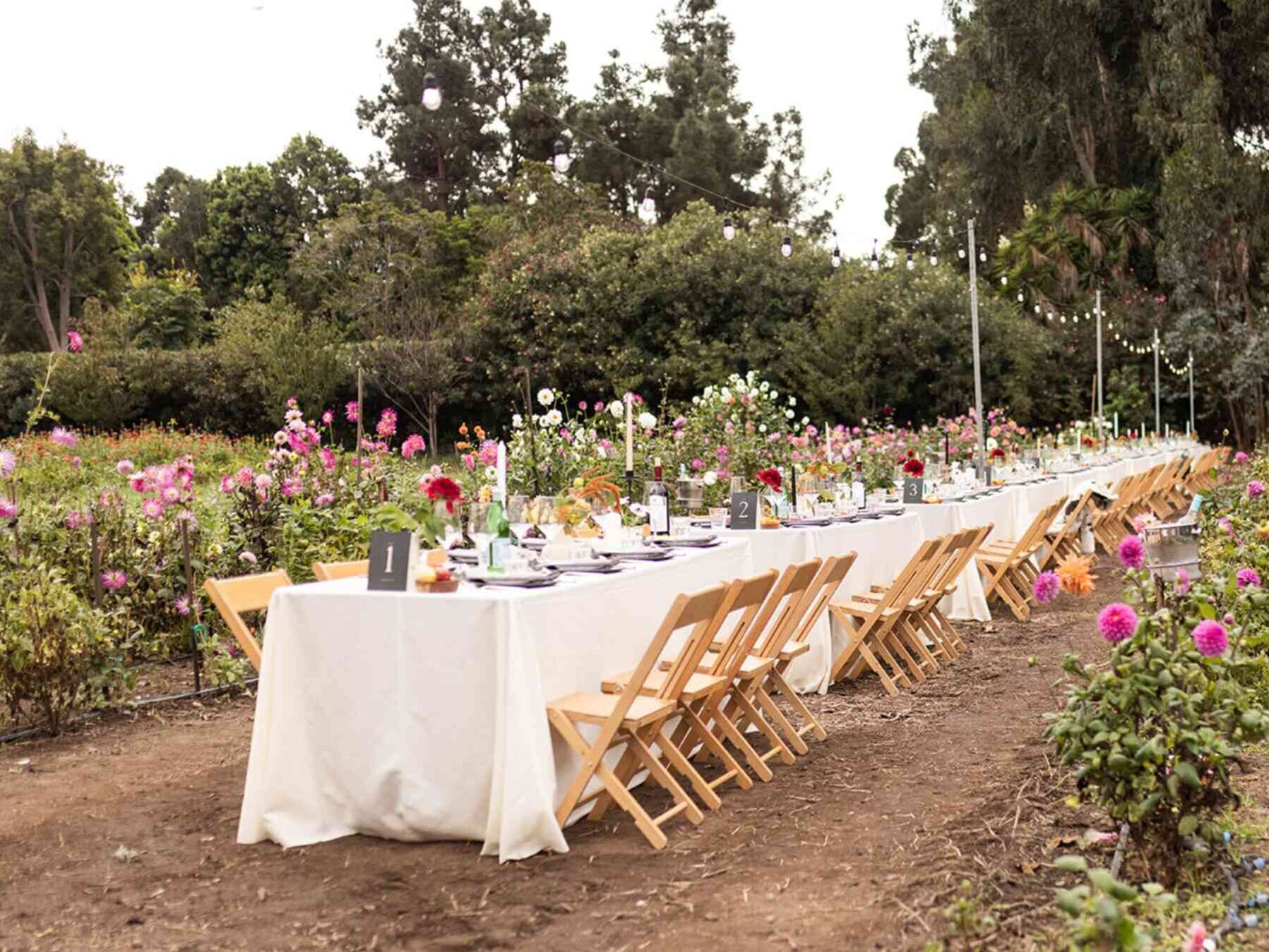 Table with flowers, white linens, and place settings at outdoor wedding in Washington state