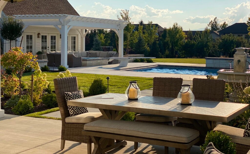 Beautiful backyard space with in ground pool, multiple seating areas, and landscaping