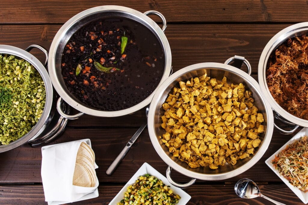 Pots of meat and vegetables on a wooden table