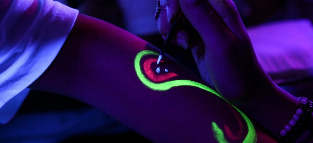 Arm being painted in neon body paint