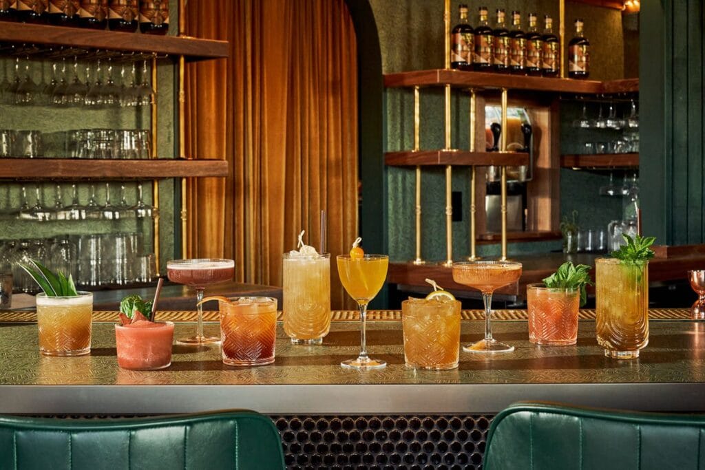 colorful mocktails cocktails lined up on a bar counter