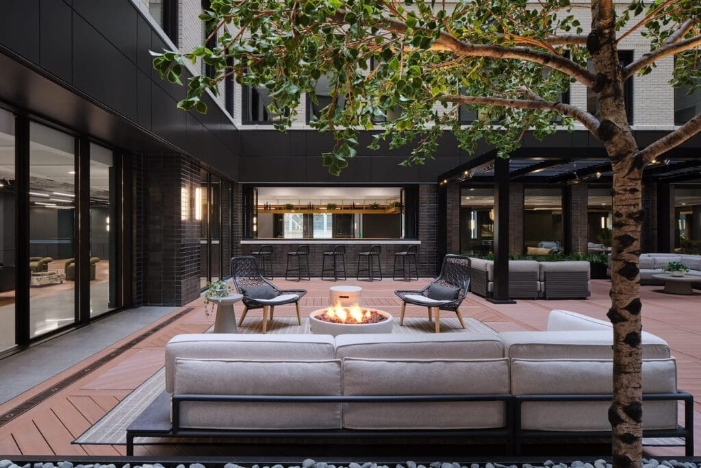 Outdoor atrium with bar area, lounge space, and a fire pit