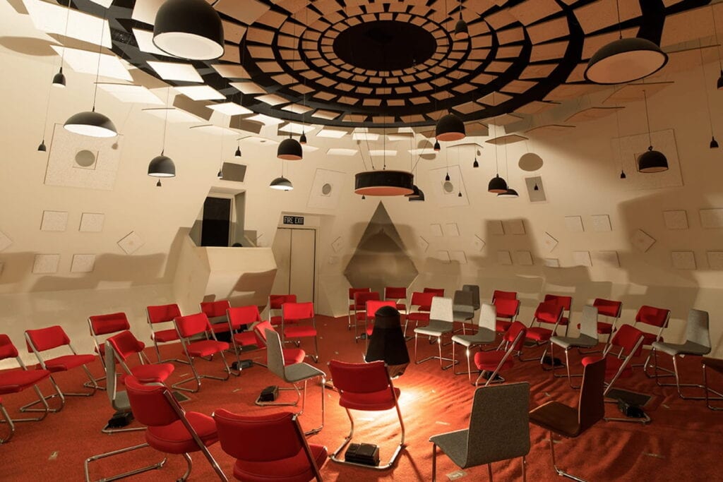 Chairs are set up in a circle in theater of sound