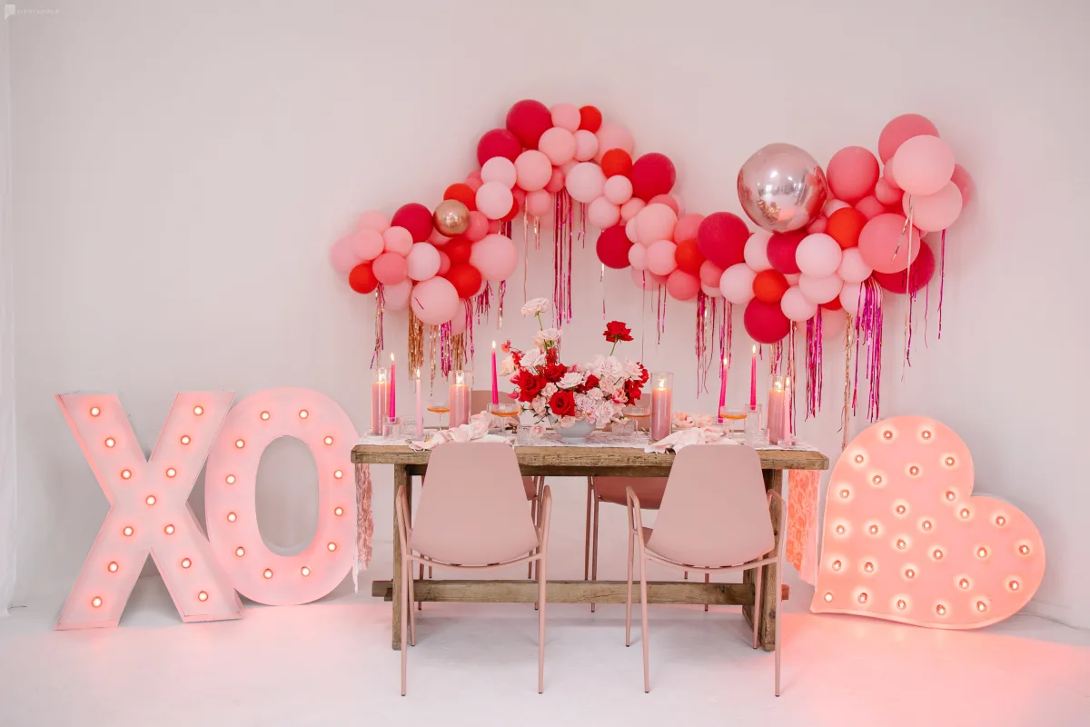 Valentine's day dinner table setting with roses and balloons