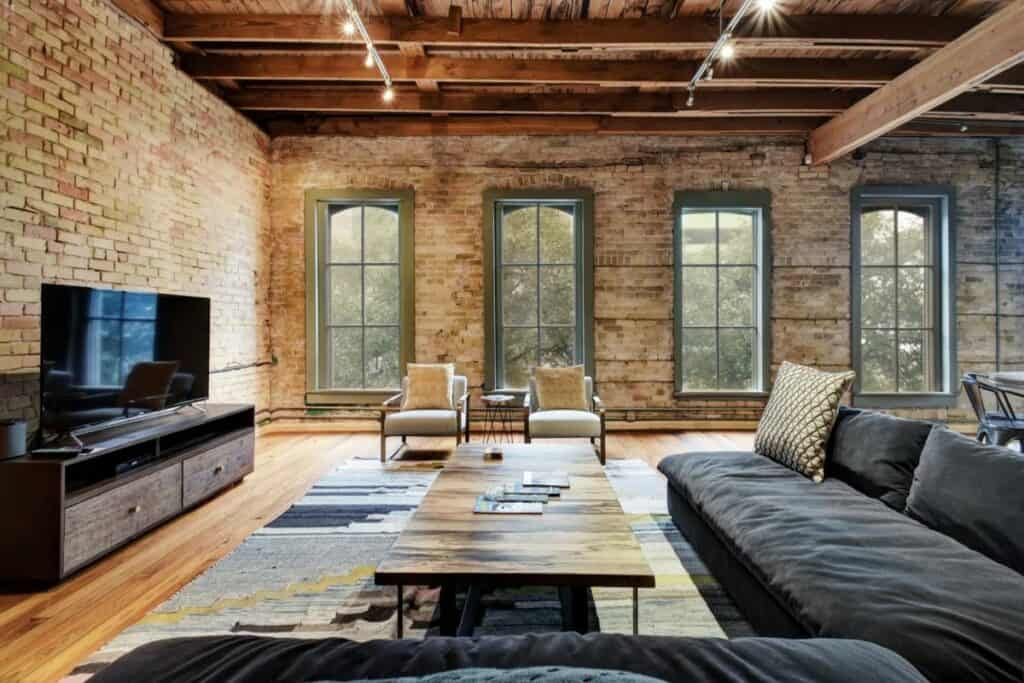 A comfortable loft with exposed brick walls and a sectional couch