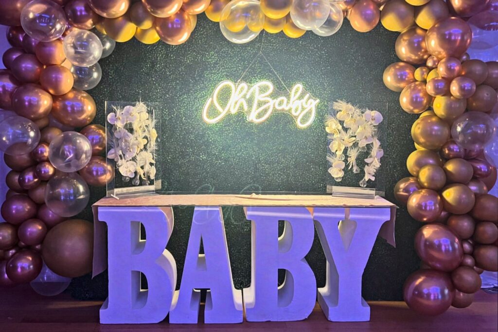 gender reveal decor with balloons, florals, and lights