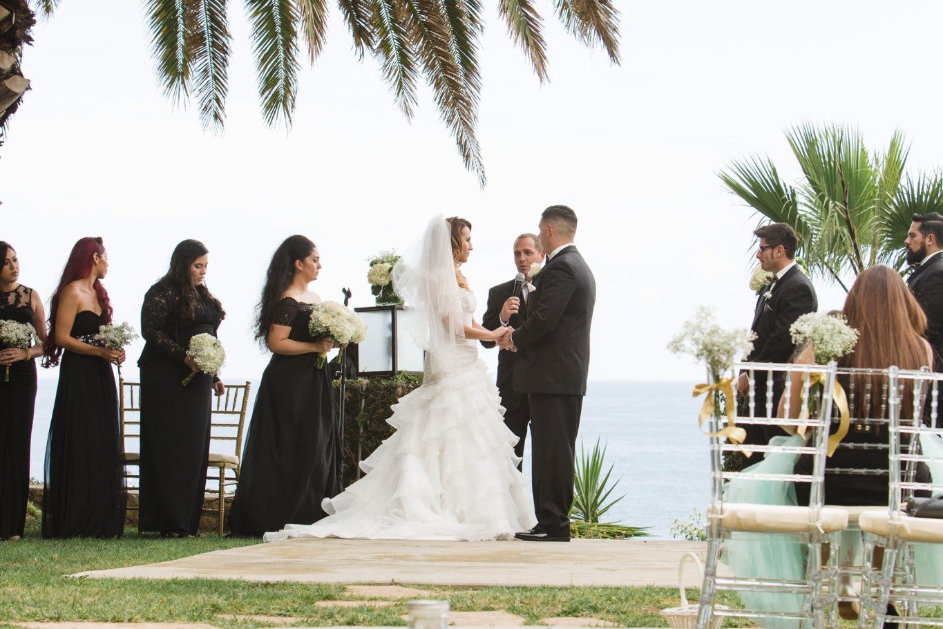 Oceanside wedding ceremony with bridal party and palm-framed Miami waterfront