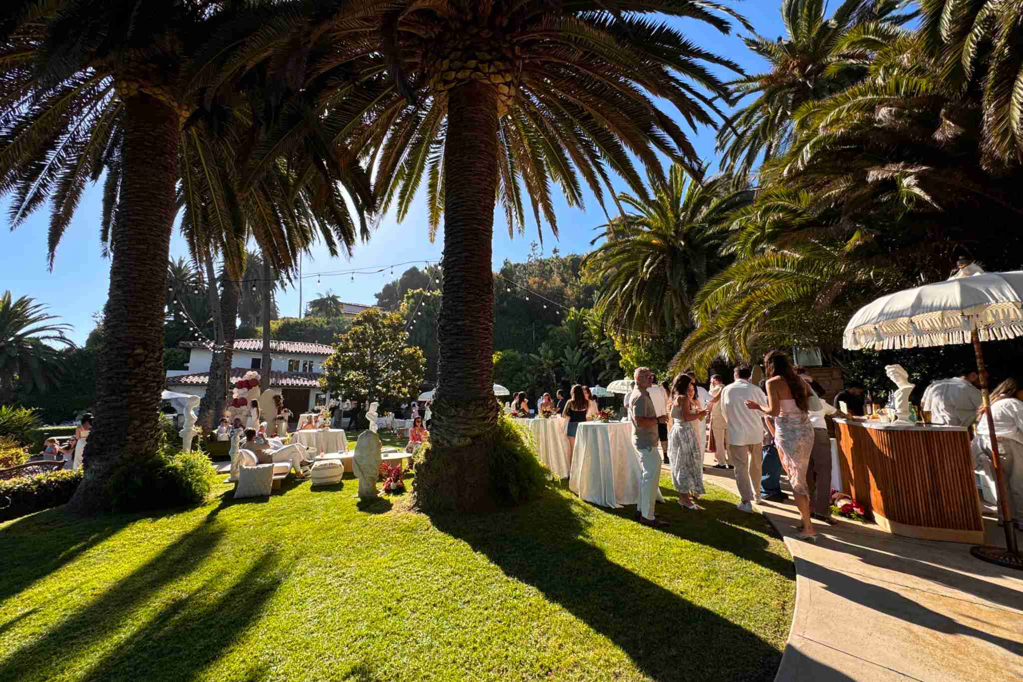 Palm-filled tropical Miami garden reception with guests mingling outdoors