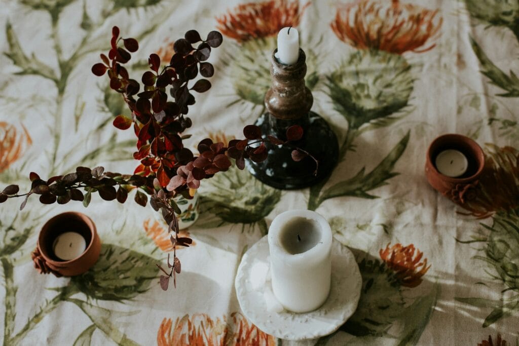 Elegant table decor, candles, tablecloth, and a dried plant for Friendsgiving gifts