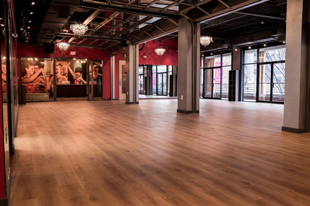 A large event space with dark red walls, chandeliers, and a wall of windows