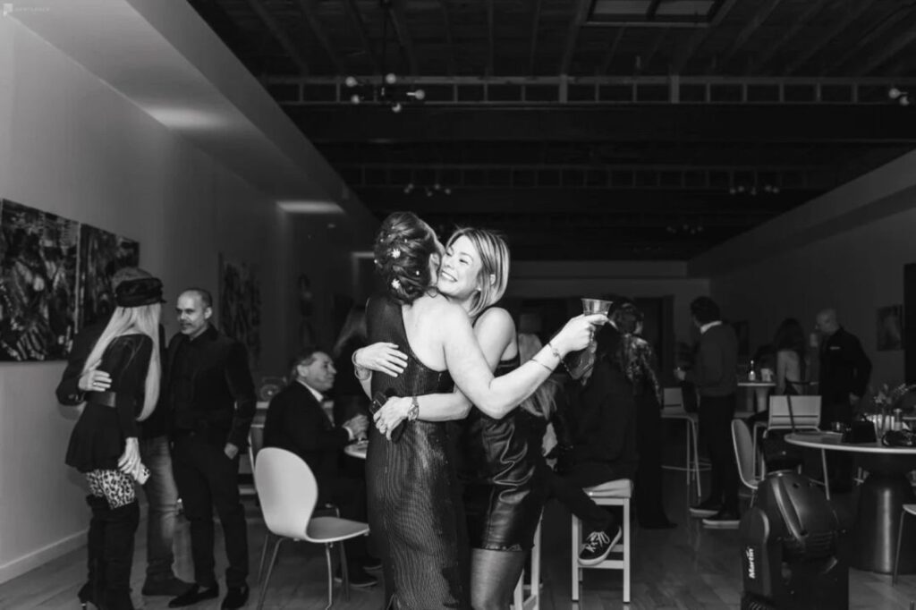 black and white photo of friends embracing at a party