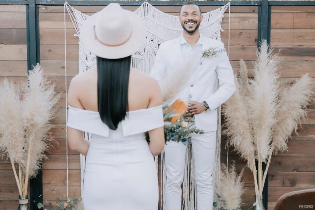 A couple meets at the altar, which is decorate with bohemian accents