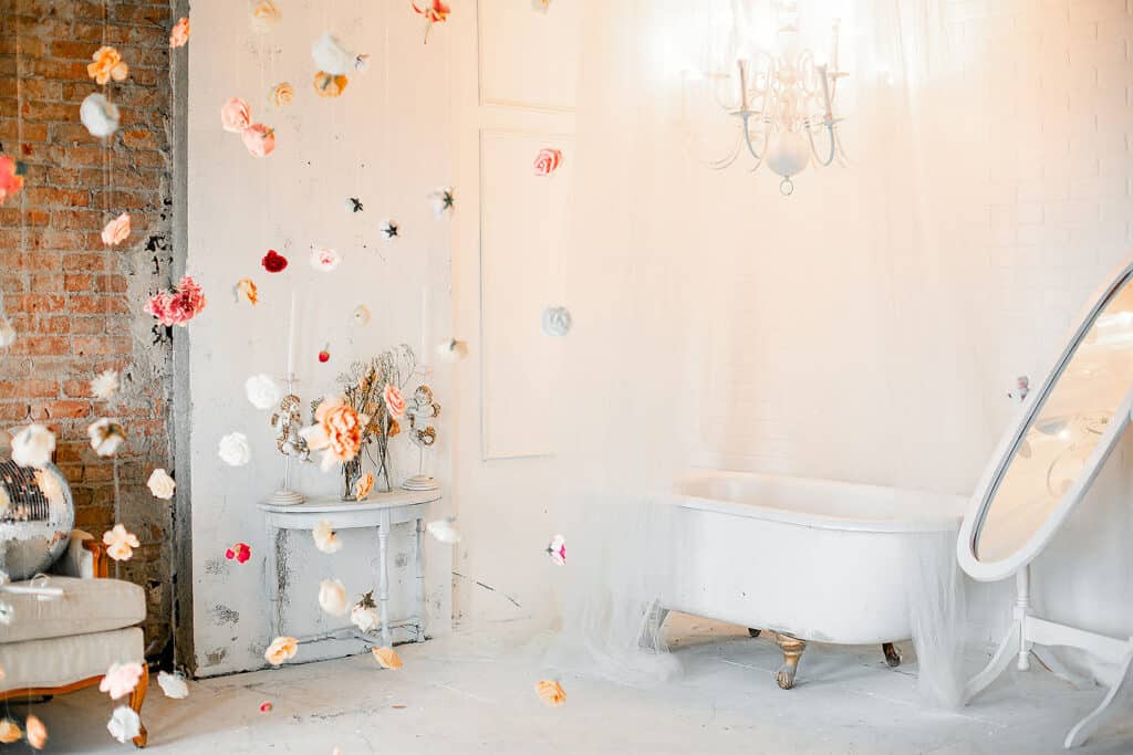 an all-white studio with floral decor