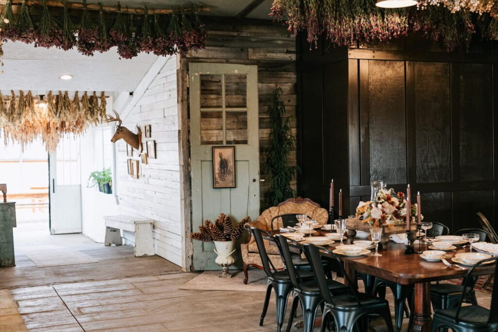 Rustic dining space decorated for small dinner with autumn-colored flowers