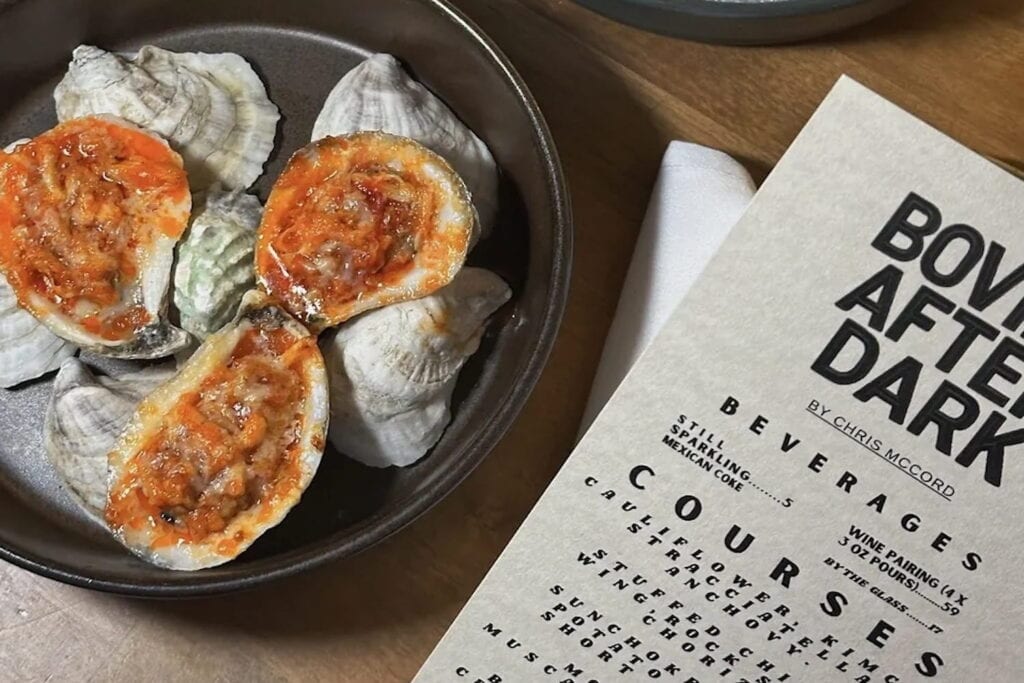 Plate of shellfish sitting next to a menu