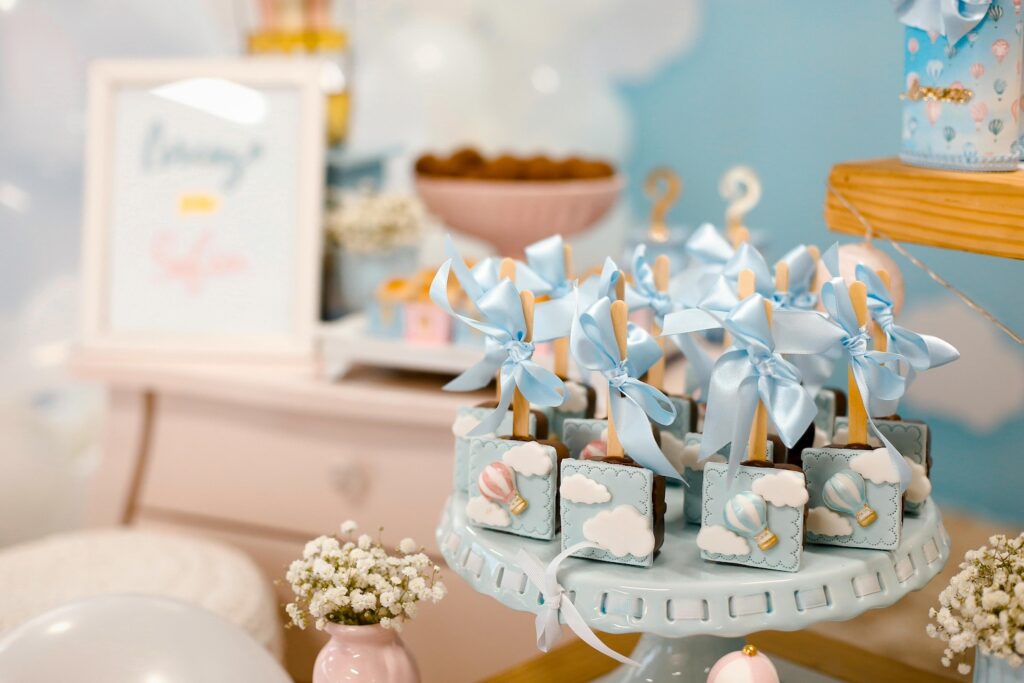 Boy-themed cake pops sit atop a cake plate at a baby event