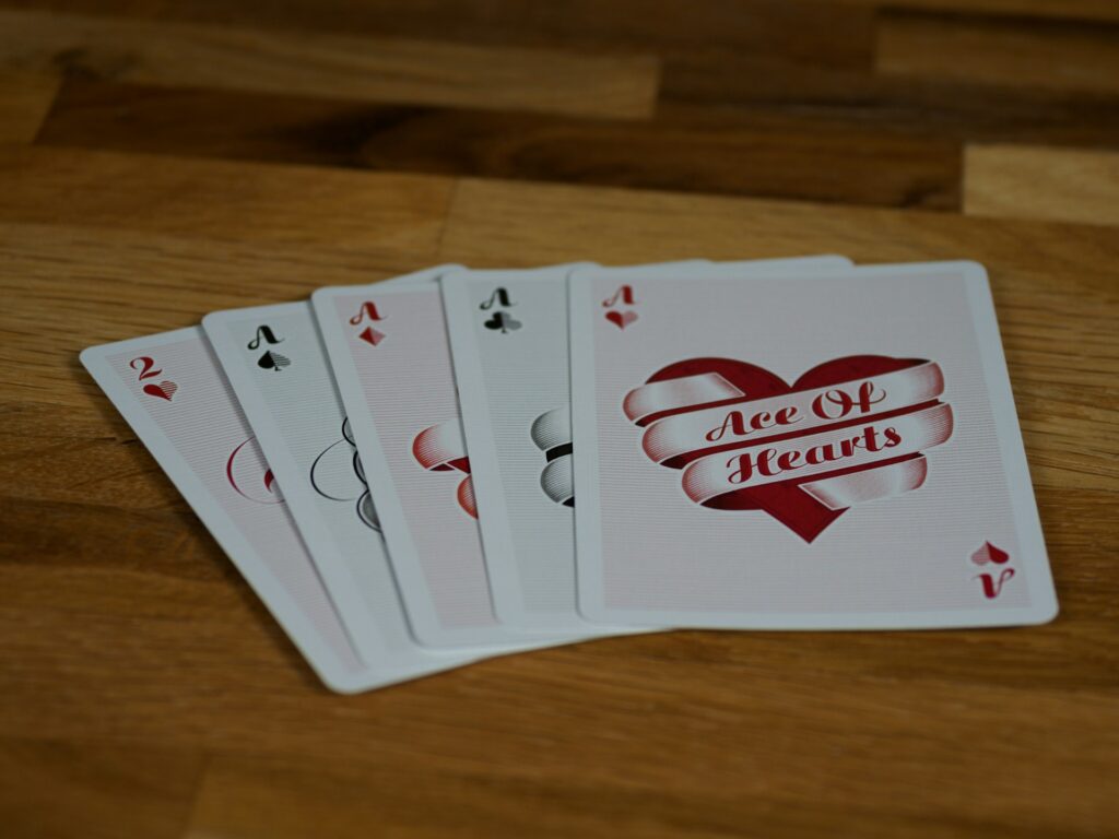 Five cards from a deck of cards fanned out on table