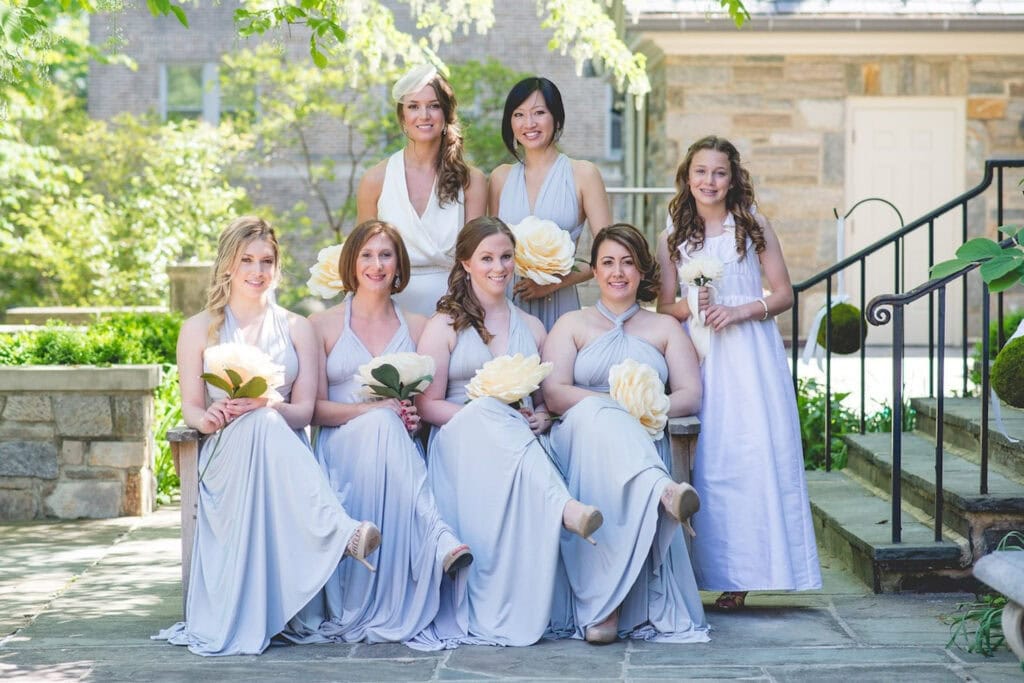 A bridal party poses outside on a stone patio