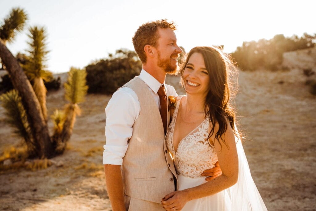 A bride and groom pose for a photo in the Vegas desert at sunset