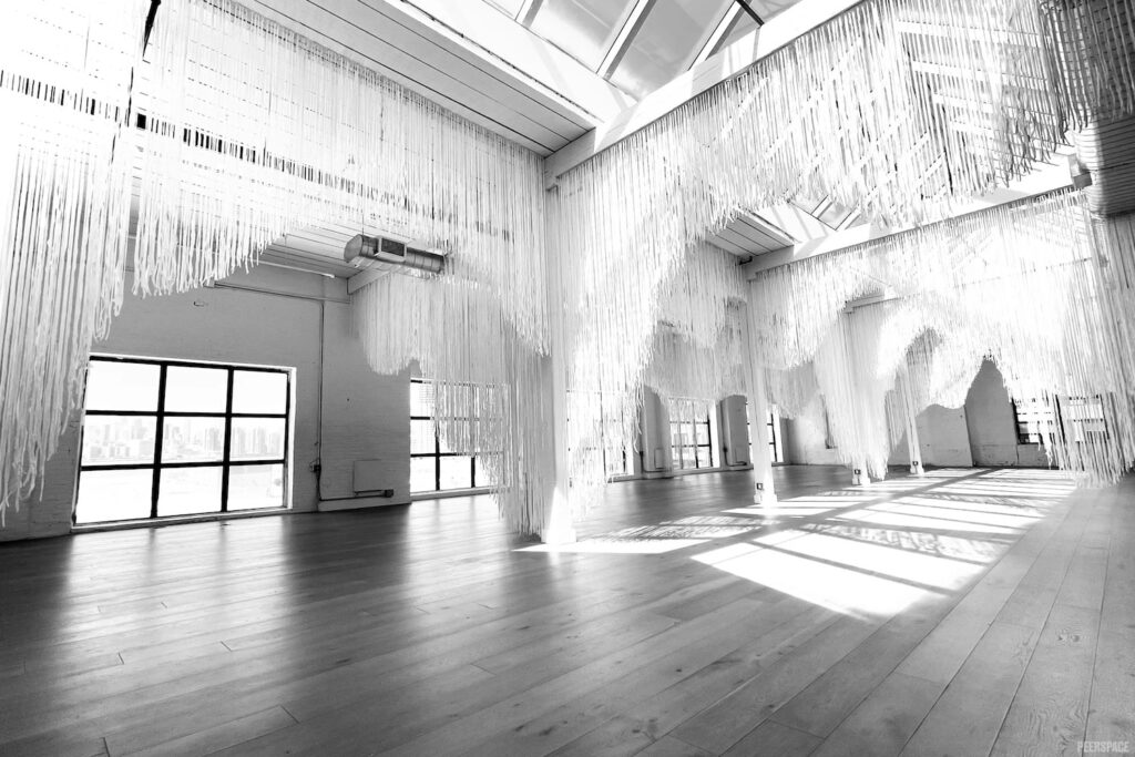 Open and airy warehouse with garage doors, high, skylit ceilings and streamers hanging from rafters