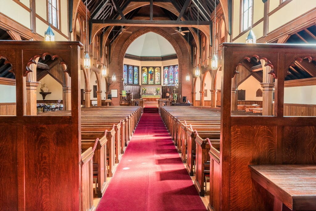 Elegant church interior with wooden pews and stained glass windows