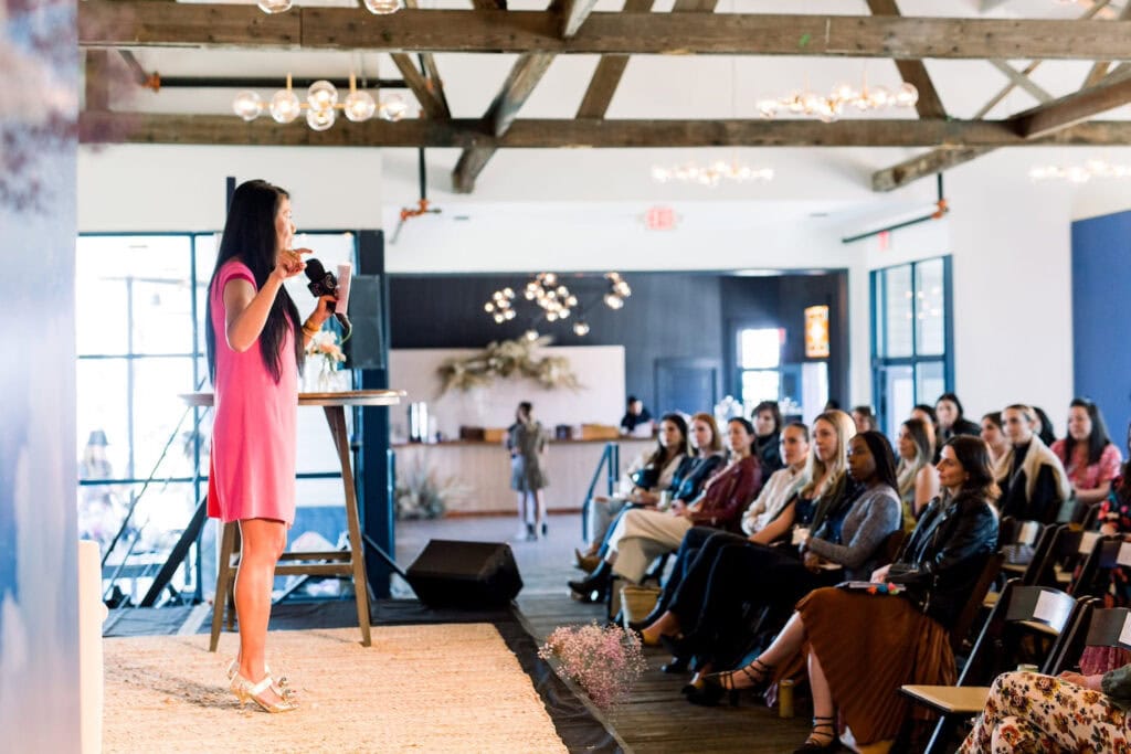 A woman on stage speaks to a crowd