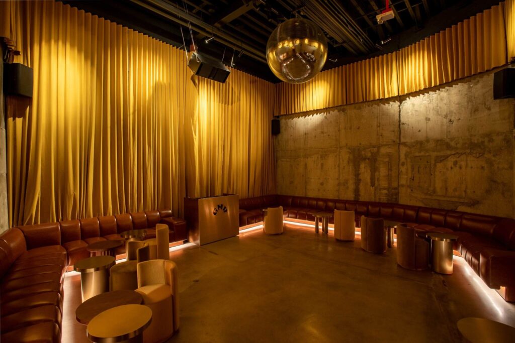 Indoor Atlanta corporate event venue with gold curtains and leather booth seating