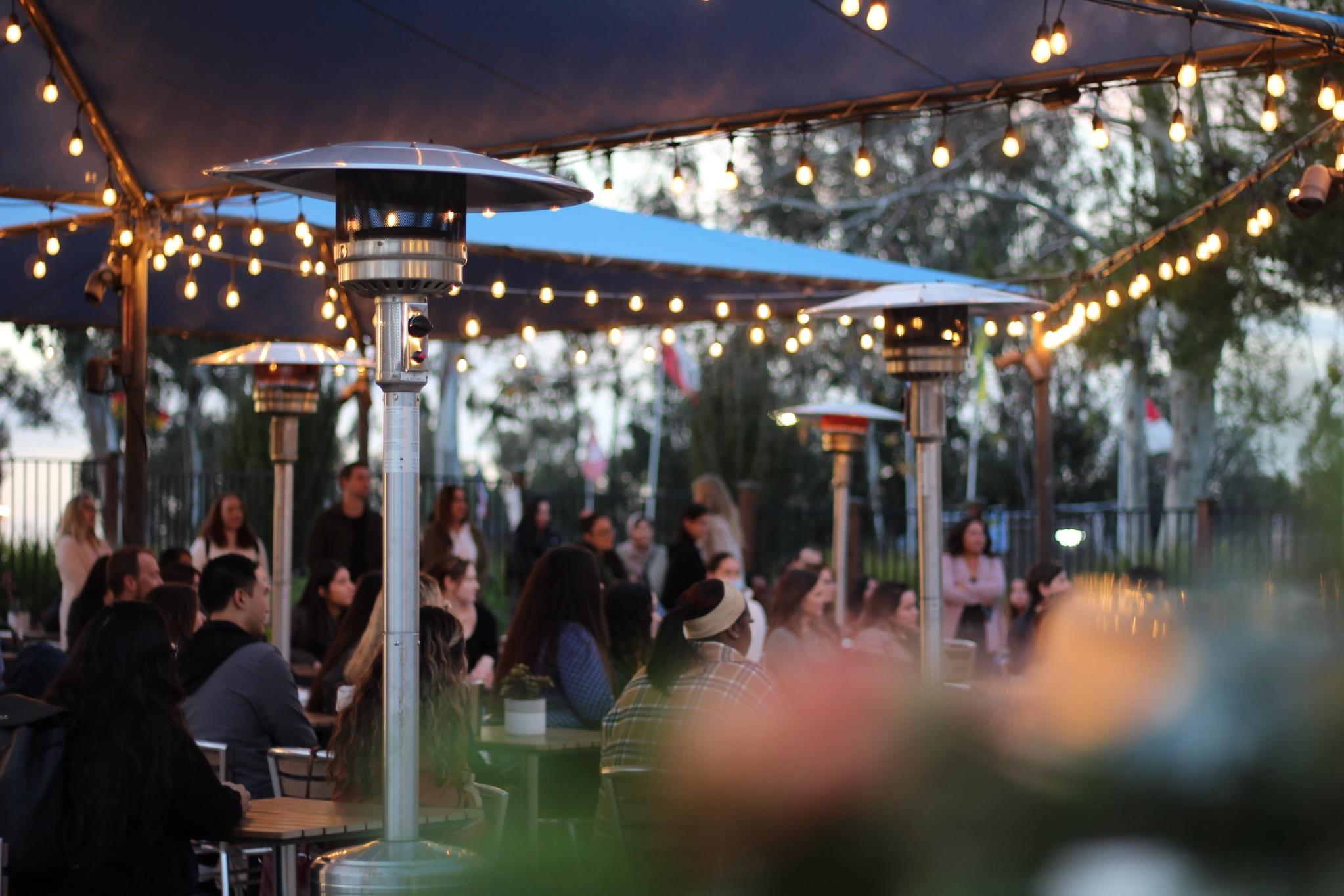 Outdoor evening networking event with string lights in San Diego