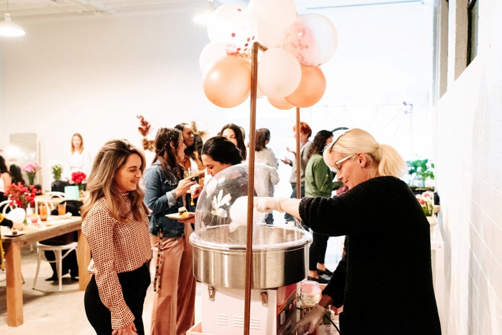 a cotton candy vendor serving a guest at an event