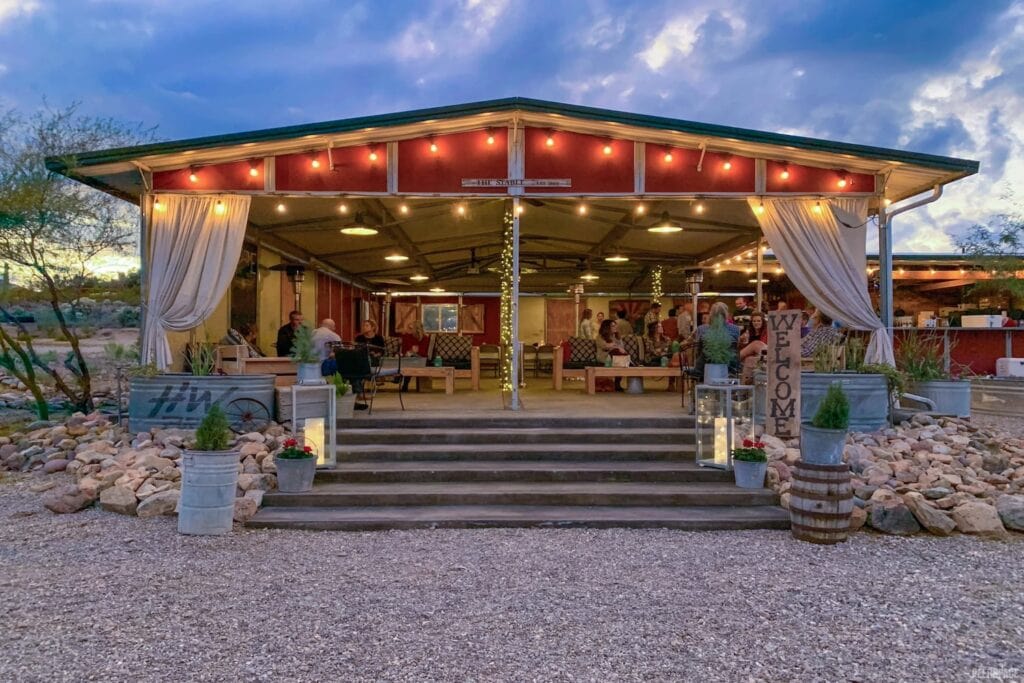 A stable lit up with fairy lights provides a rustic reception space in the desert