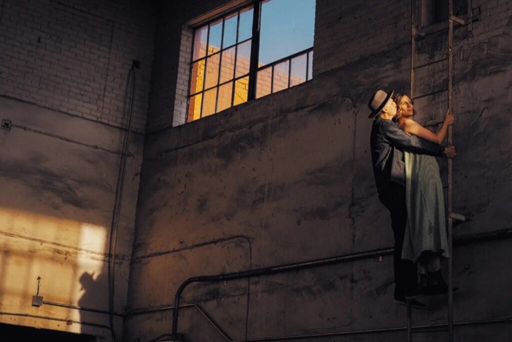 couple in black suspended from black wall
