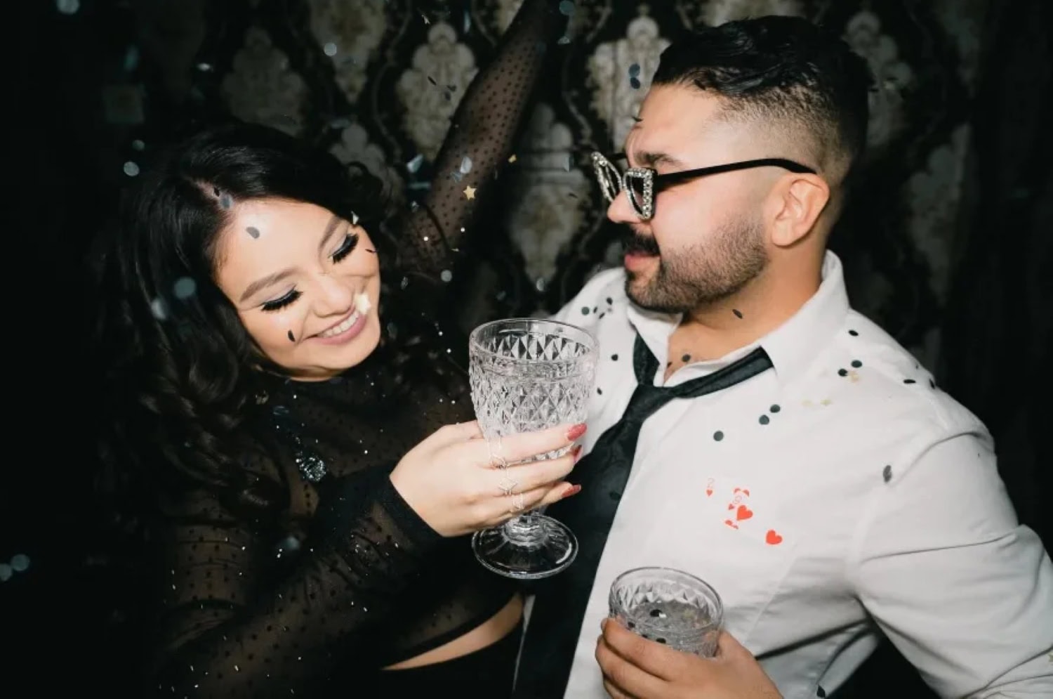 a couple in formal wear celebrating with drinks