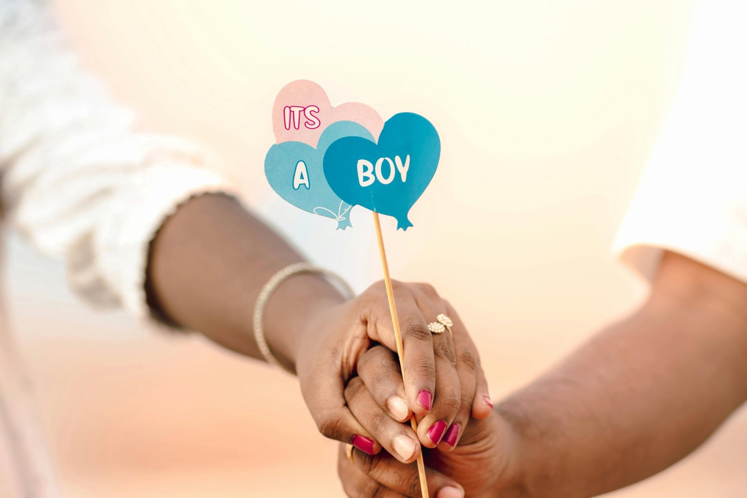 Couple holds an "It's a Boy!" sign