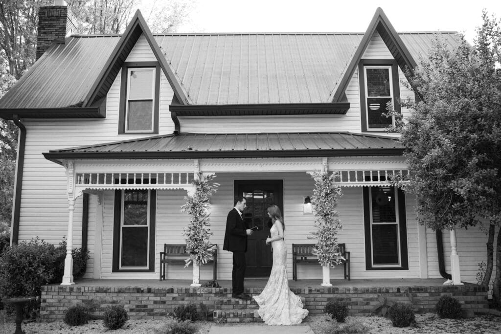 A bride and groom stand out front of a historic home
