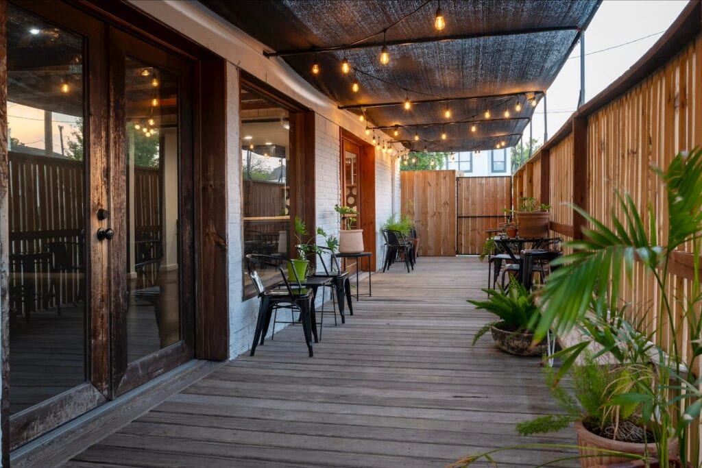 Covered patio area in Dallas with wood floors and string lights