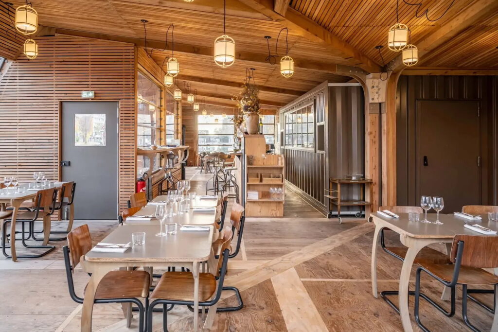 Warm, all wooden interior of a restaurant space with dim lights and minimalist decor