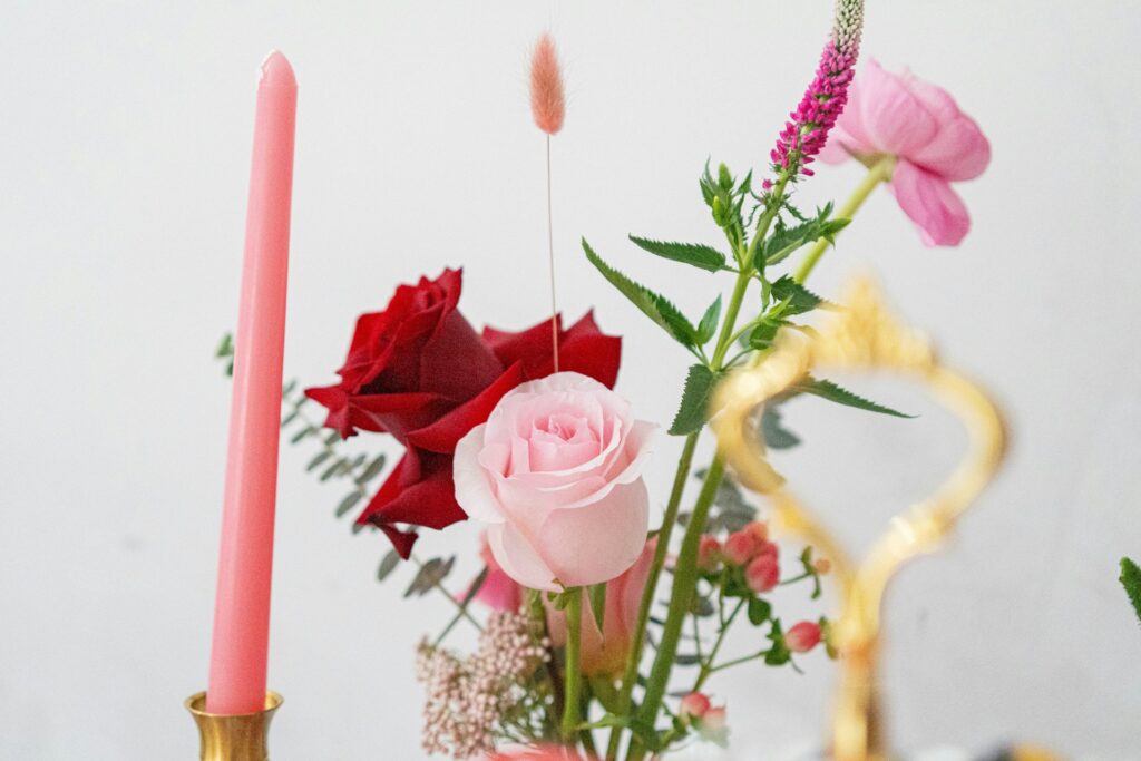 Galentine's decor including pink and red roses, pink candles