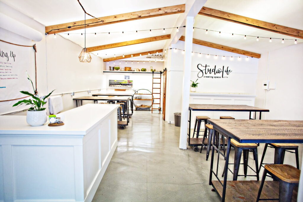 Clean creative space in Seattle with tall wooden tables, wooden beams along ceilings and crisp, white walls
