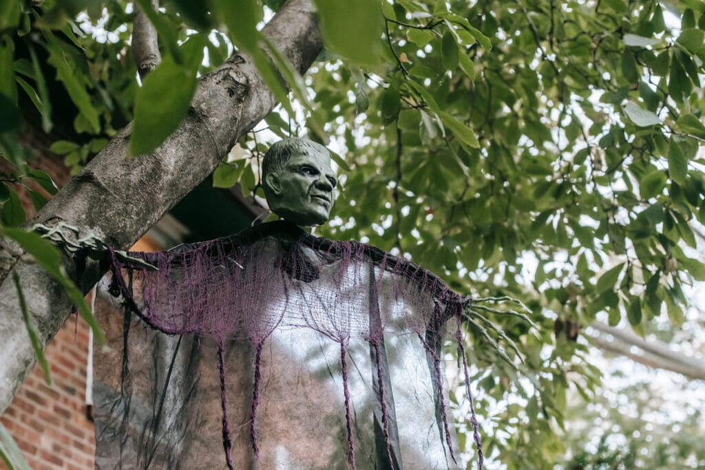 Creepy Halloween decoration of a floating head and hands hang from a tree