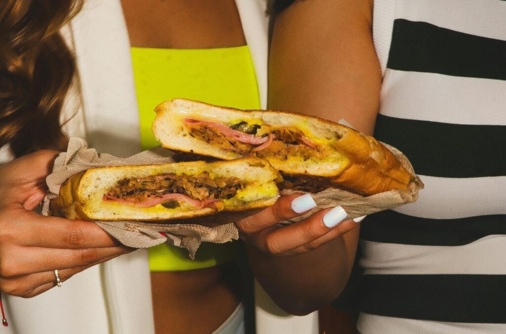 women holding cubano sandwiches