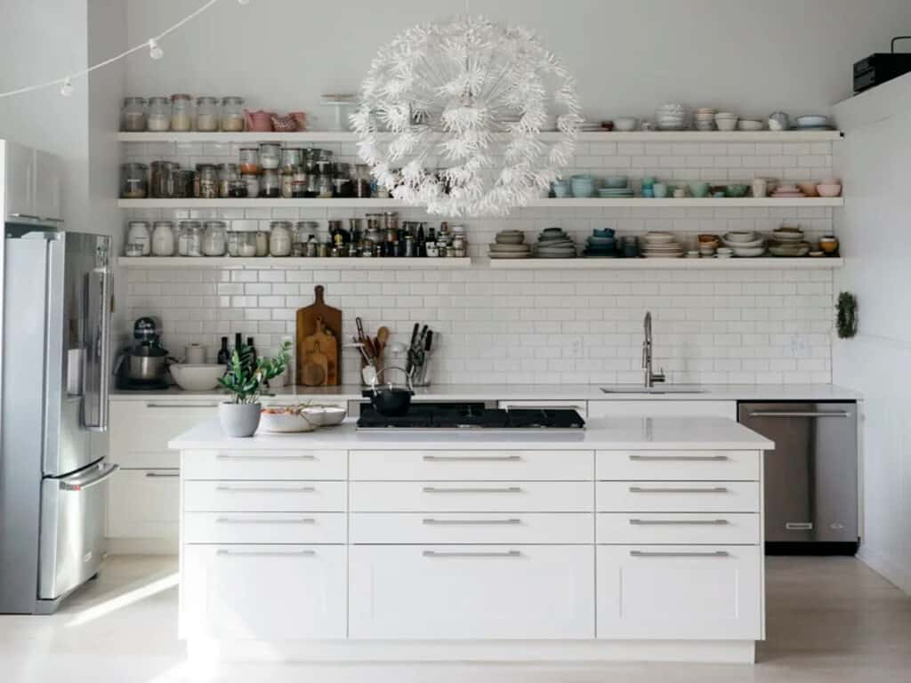 An all-white kitchen with stainless steel appliances