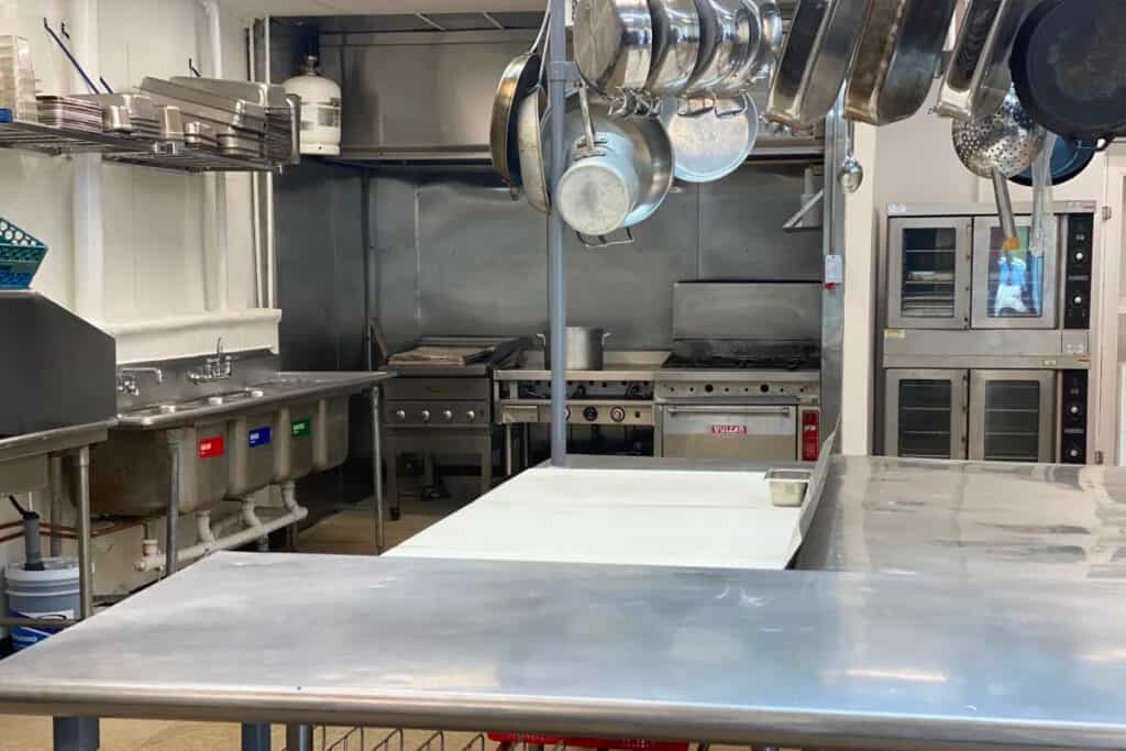 A commercial kitchen space with stainless steel appliances and cookware