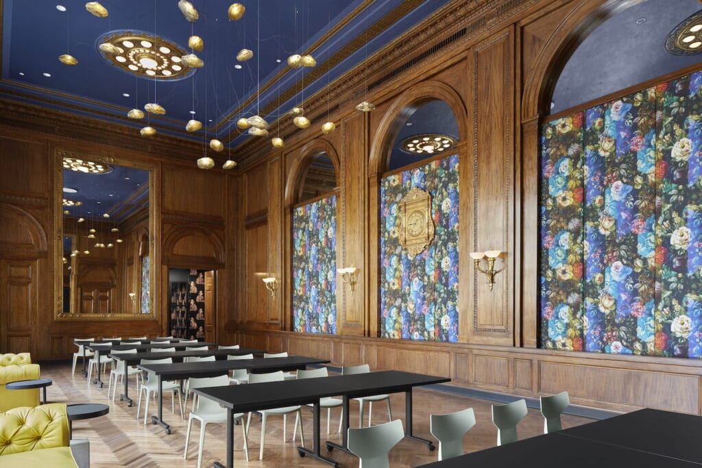 An historic event space with tall, wood-paneled walls, larger mirrors and glowing sconces
