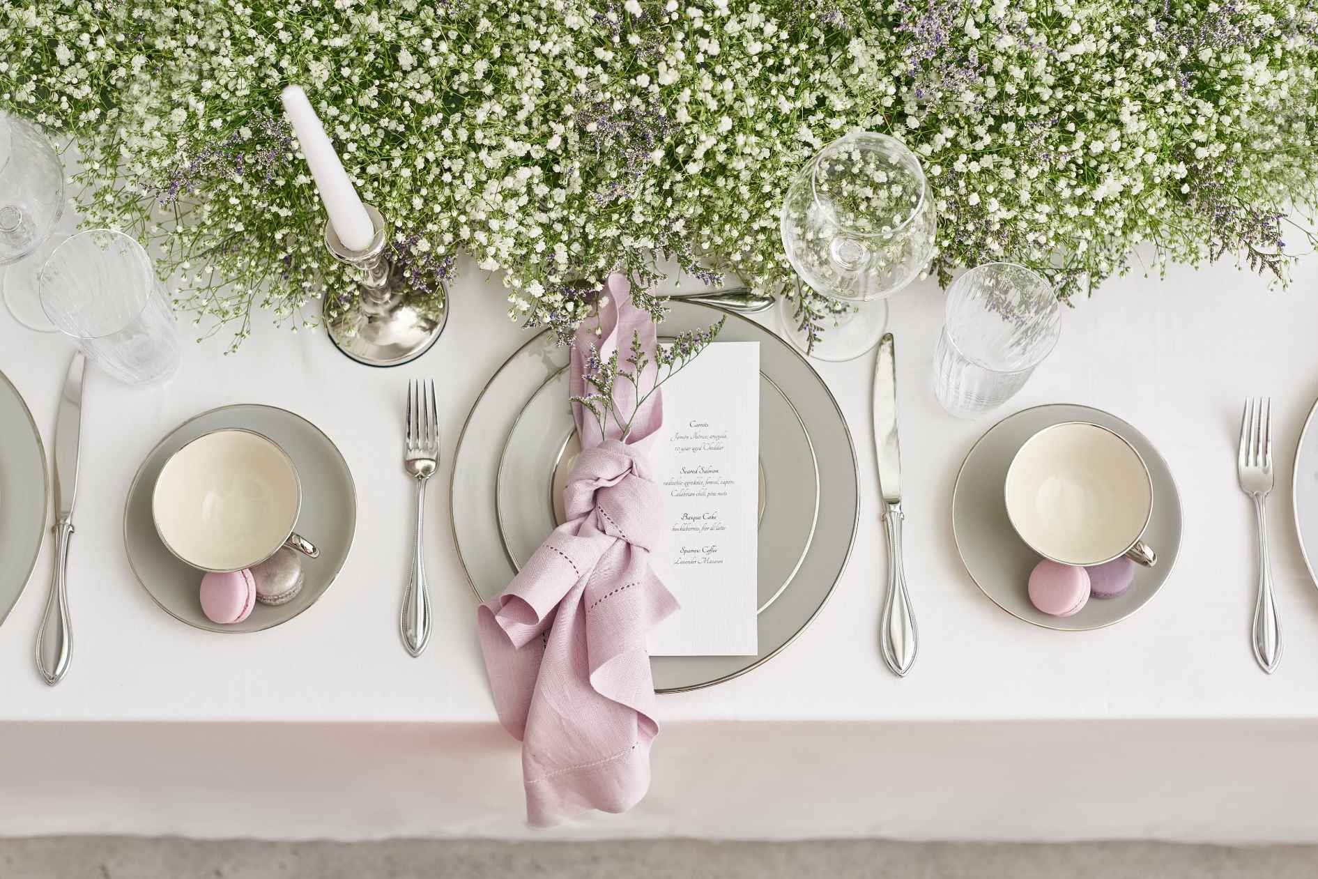Close-up Gold Coast event table with florals, menu cards, and place settings
