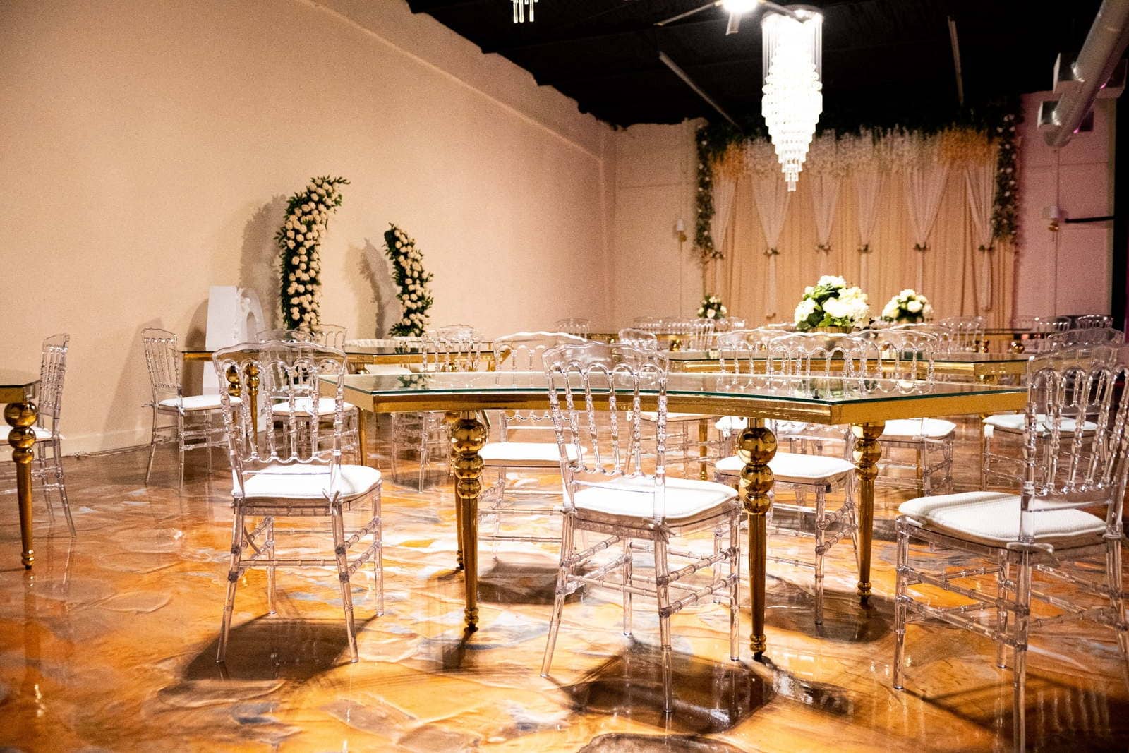 Houston ceremony setup with acrylic chairs, floral installations, and draped backdrop