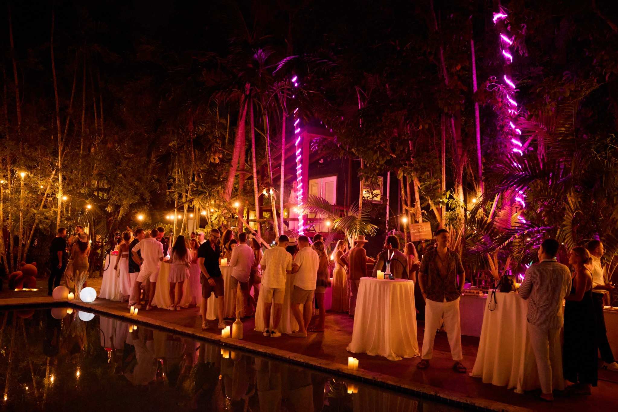 Neon-lit nighttime Miami event with formal guests and palms