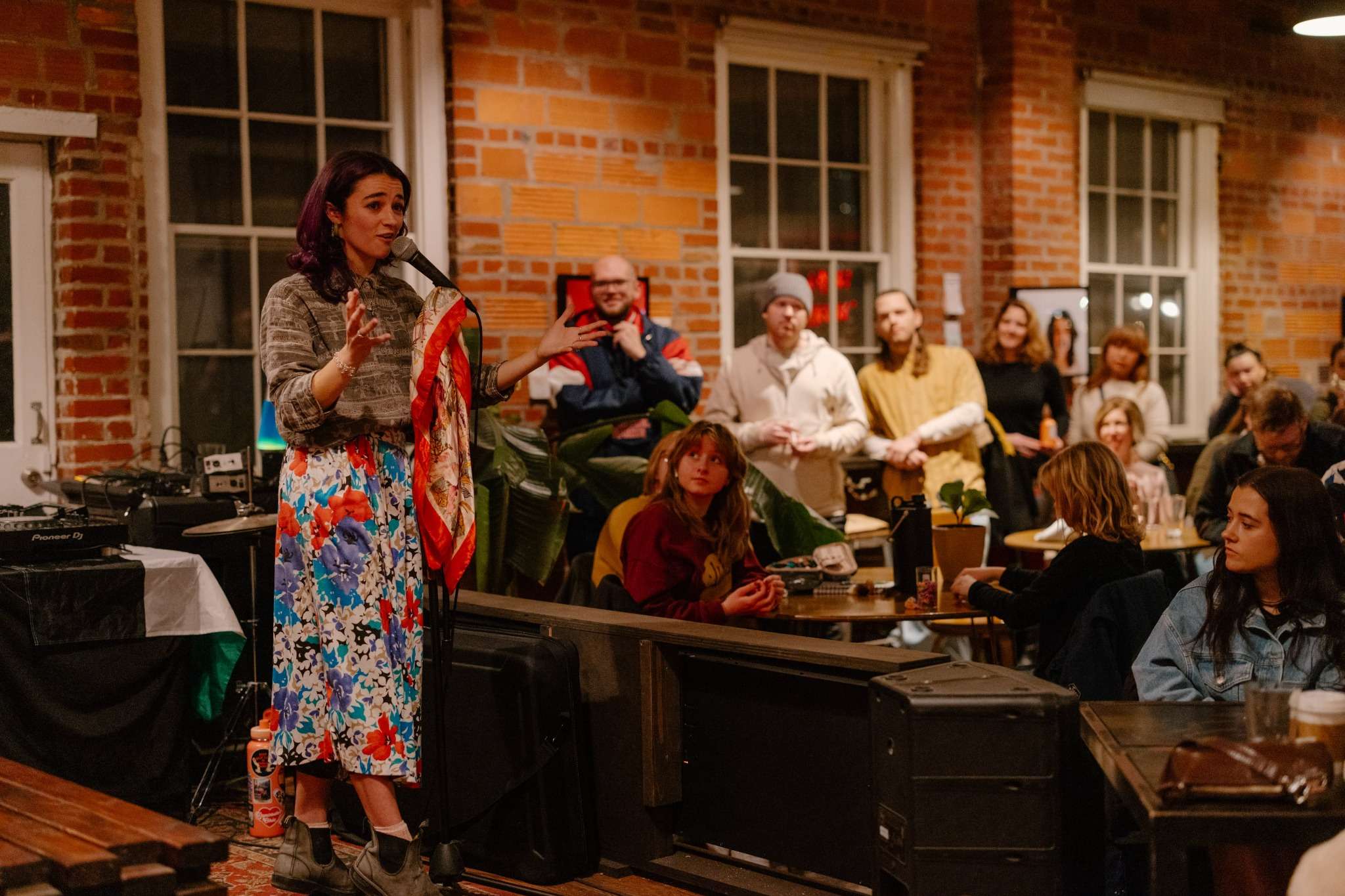 Speaker addressing audience in a New Orleans brick-walled event venue