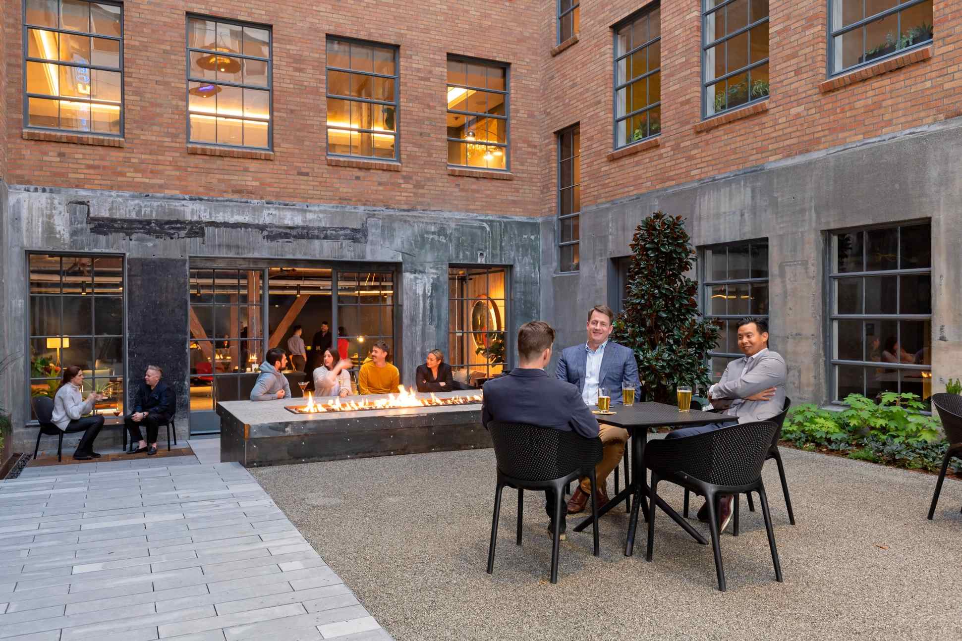 Modern Seattle courtyard event venue with guests socializing around fire feature