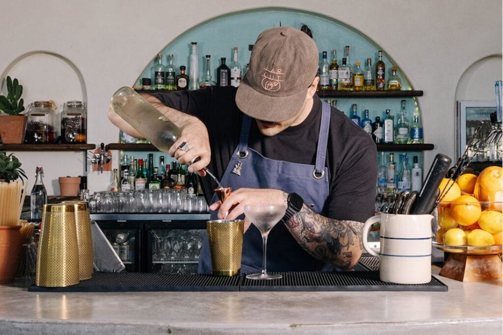 A bartender mixes drinks at Dallas' Far Out restaurant