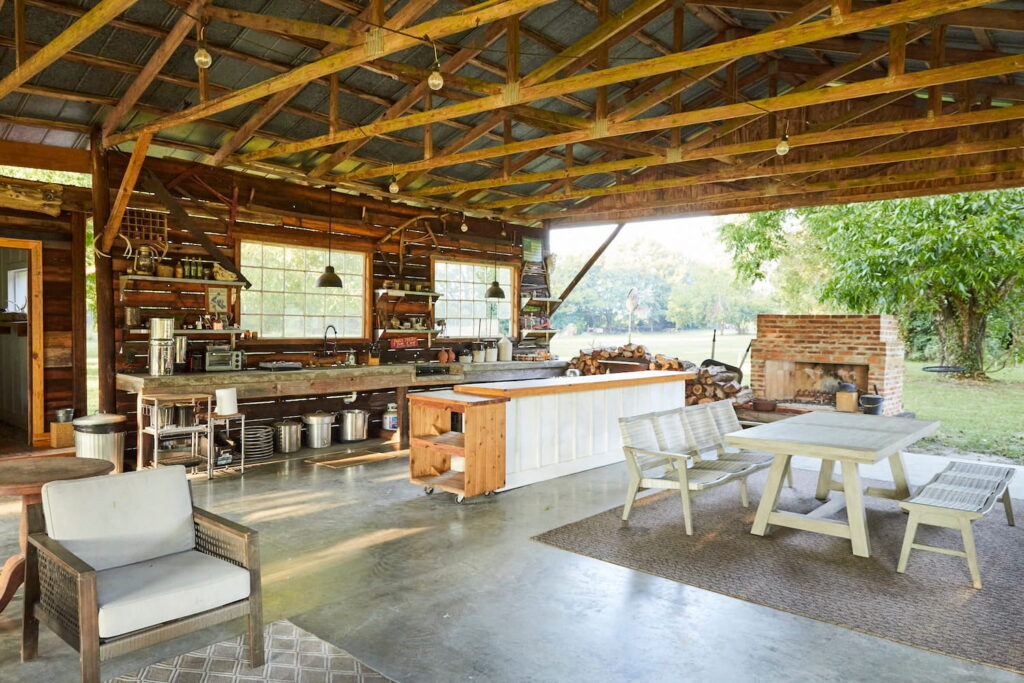 Open air gazebo living space with a kitchen, fireplace and outdoor living room